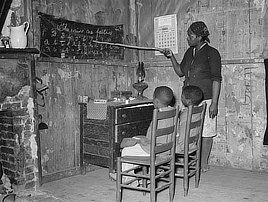 Mother teaching children in home of sharecropper, Transylvania, Louisiana. Photo by Rusell Lee, 1939